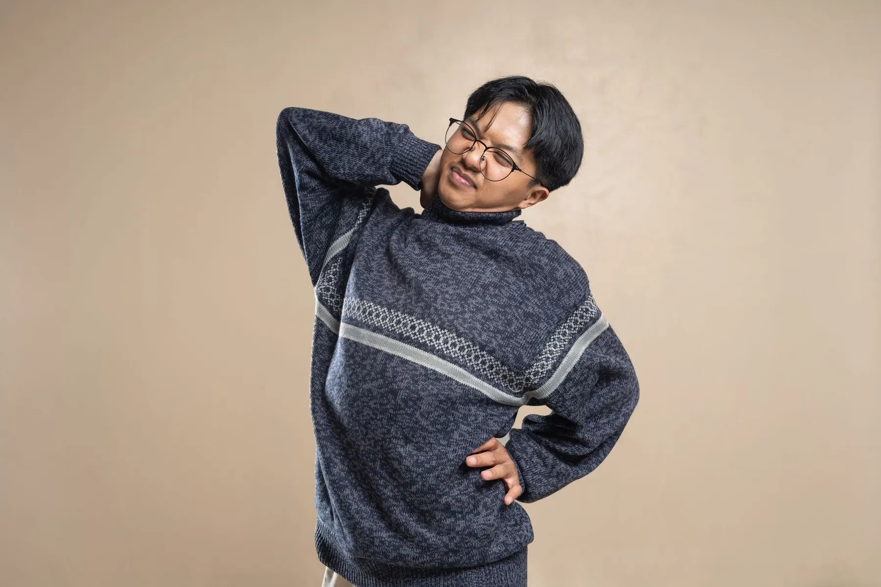 A man holding his lower back and neck in discomfort