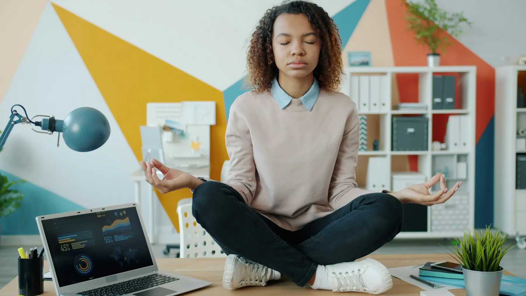 A woman taking a calm breathing break at her desk