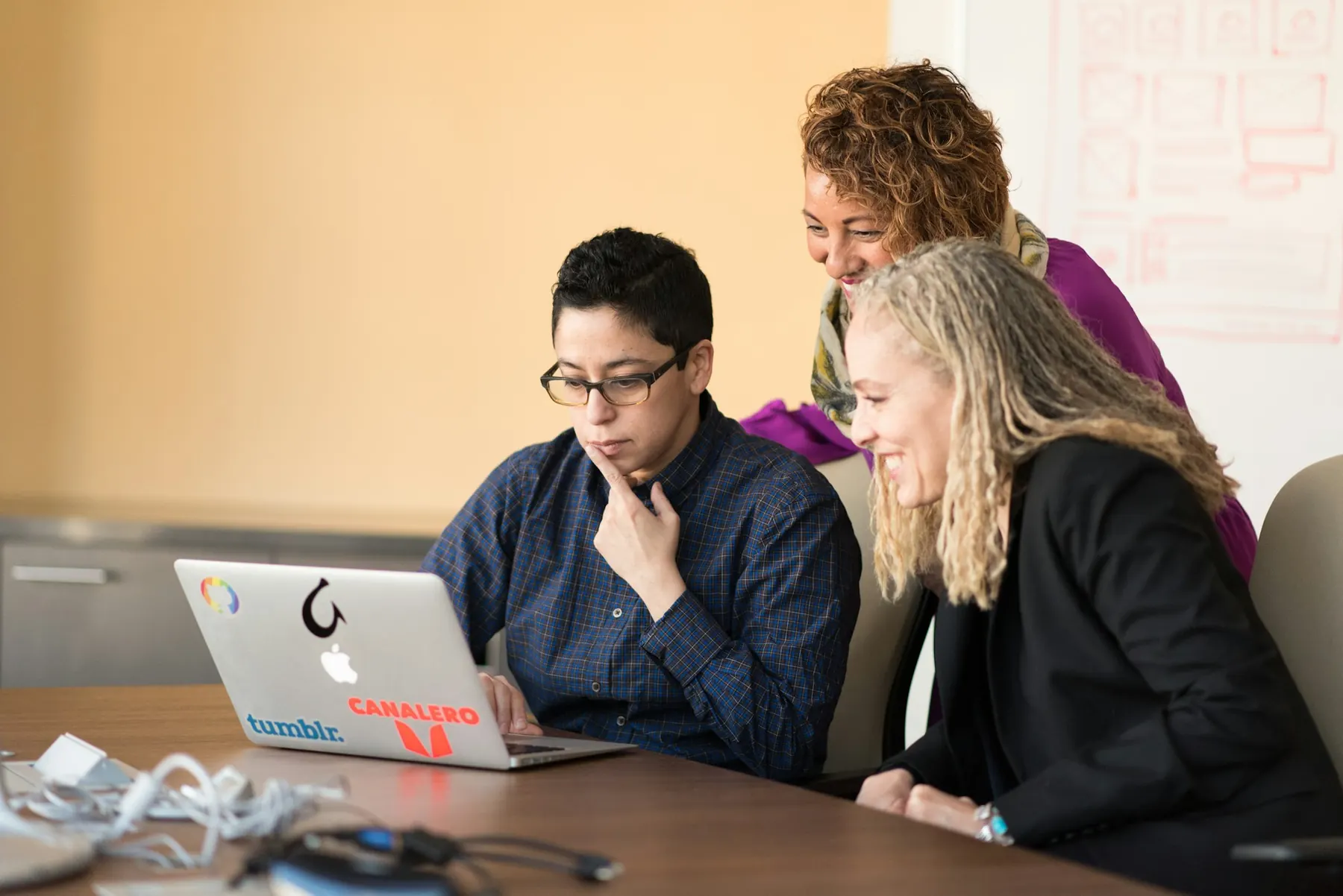 Three colleagues reviewing results on a laptop