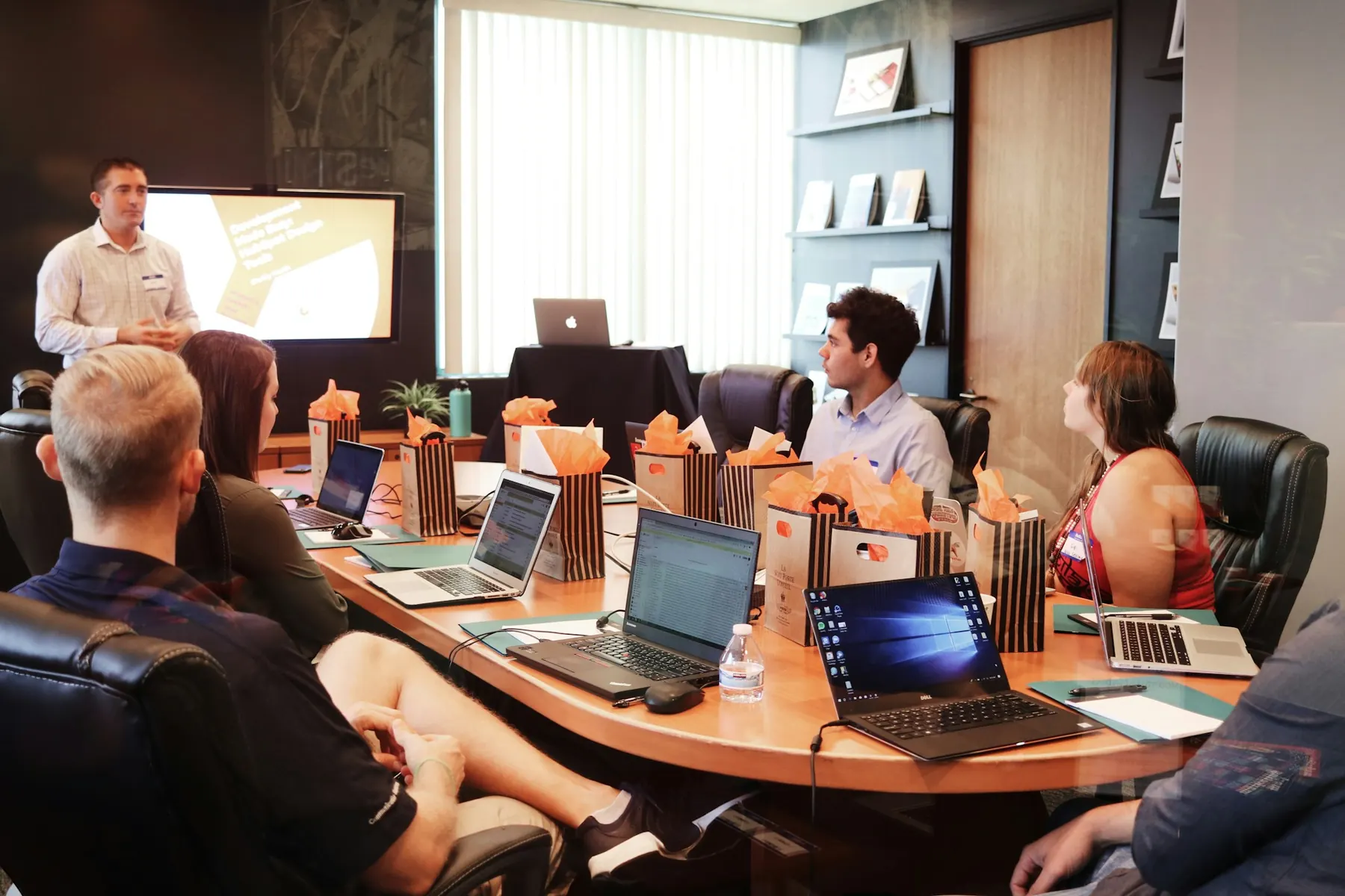 A facilitator leading a workshop with colleagues around a table